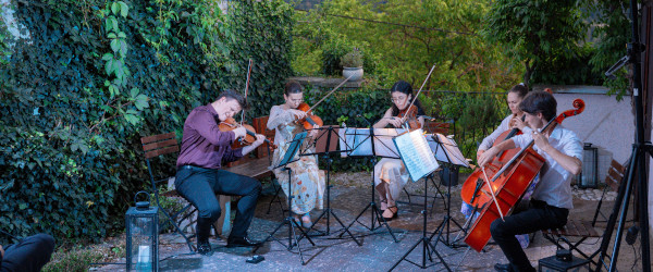 Quintett auf einer Terrasse vor dem Gebirge